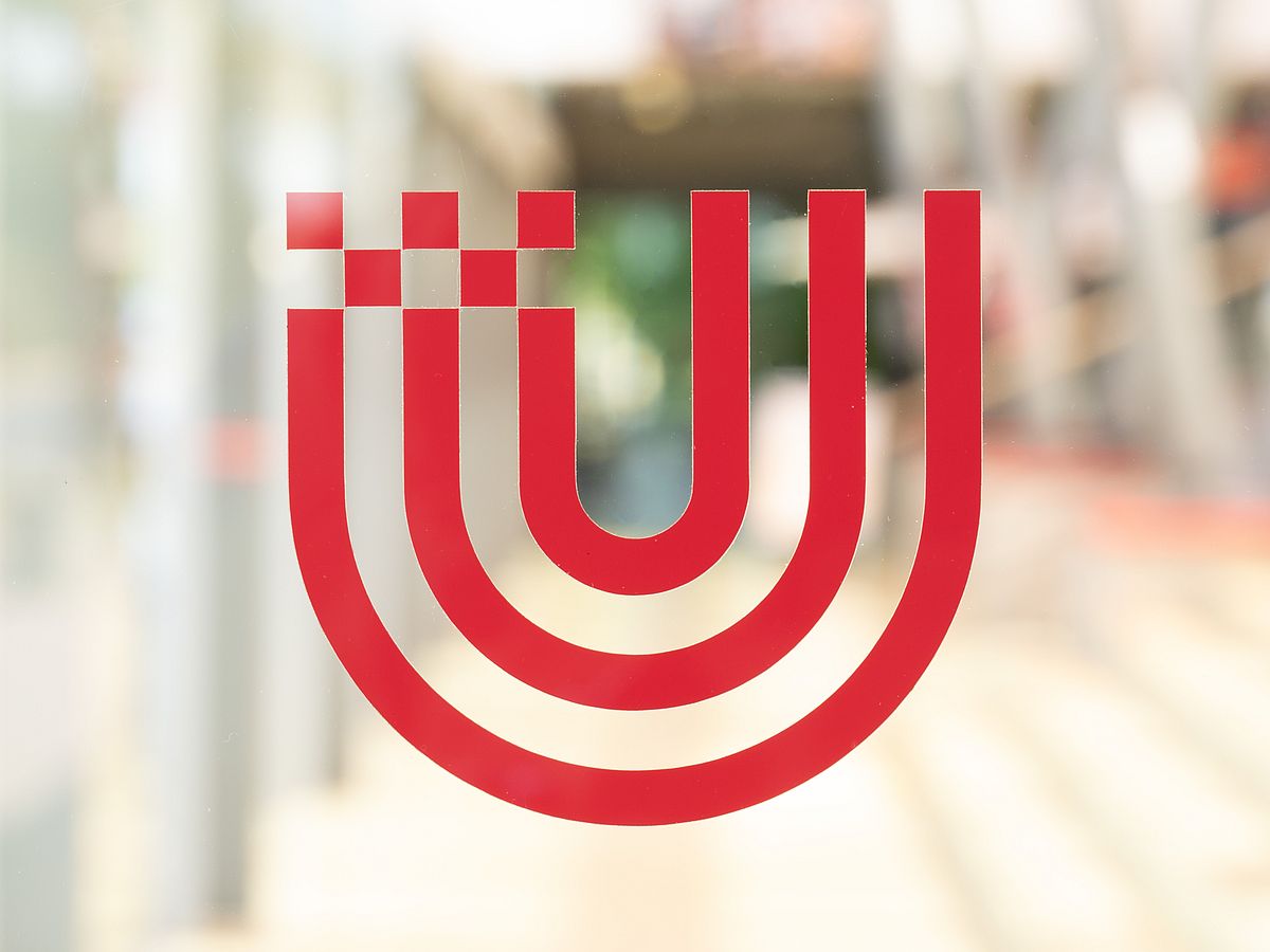 Logo of the University of Bremen on a glass pane.