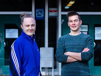 Zwei junge Männer schauen in die Kamera