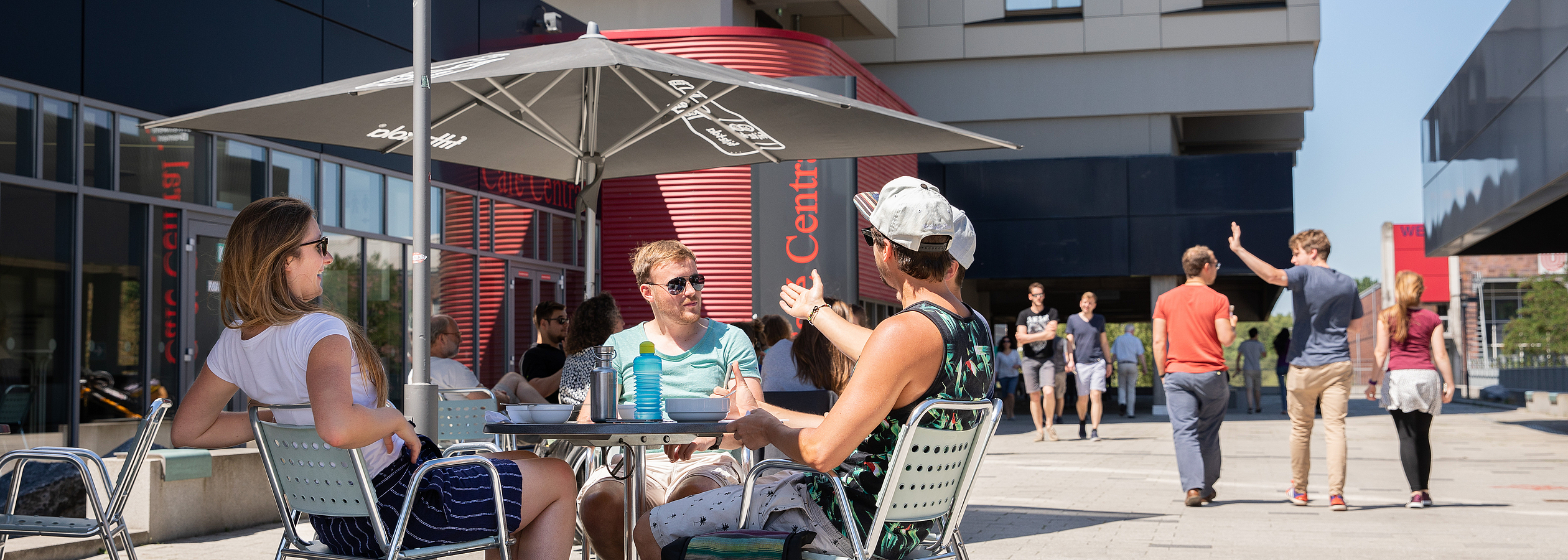 Studierende sitzen vor dem Café Central an einem Tisch.