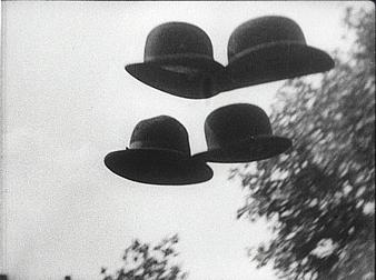 filmstill: Fliegende Bowlerhats vor Himmel in s/w