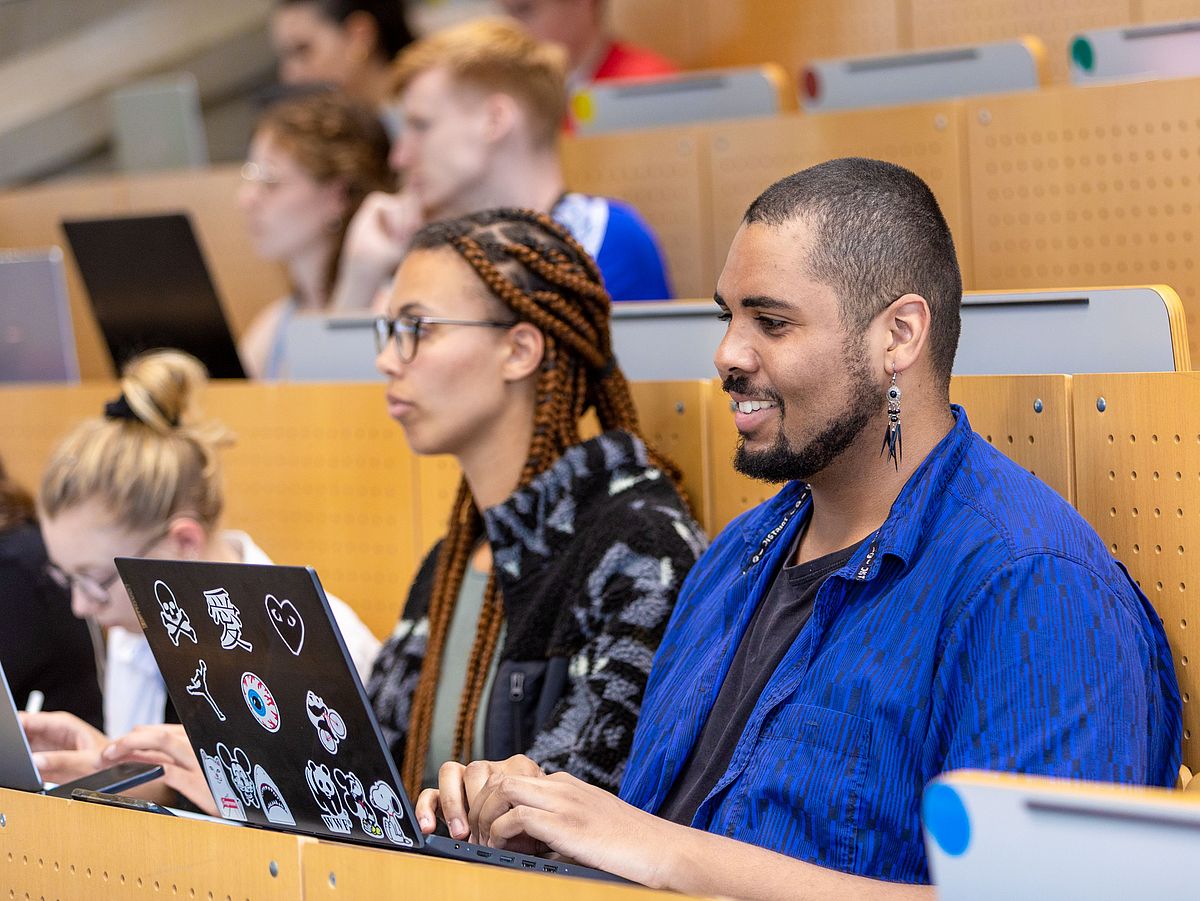 Studierende sitzen im Hörsaal bei einer Vorlesung