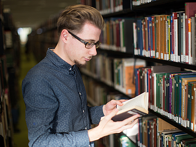 A library visitor browses through a book.