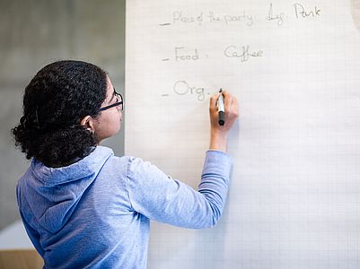 A person writes on a flipchart.