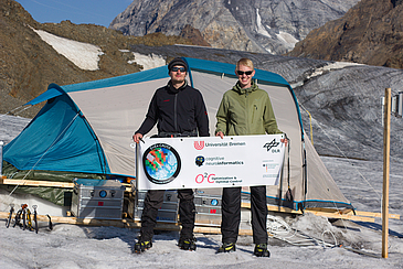 Zwei junge Männer stehen auf einem Gletscher