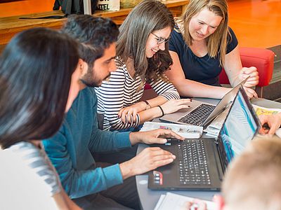 Junge Menschen arbeiten am Laptop.
