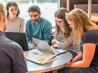 Young people work at a laptop.
